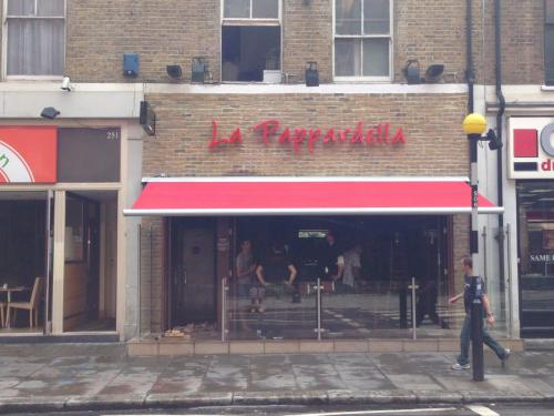 Electric folding arm awning recover at La Pappardella in Old Bromton Road, London.<br /> 
