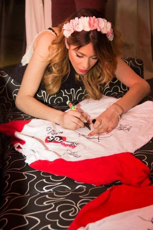 Martina firmando una camiseta de Radio Disney.