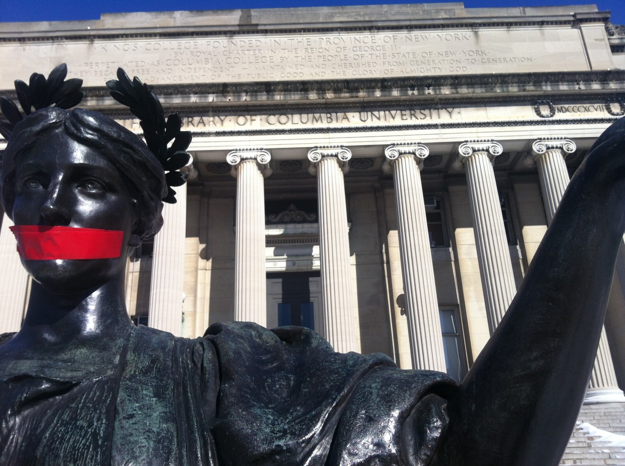 Activists use red tape to symbolize the administrative attempt to silence survivors. Picture taken at Low Library, the seat of the Columbia University administration. - Photo credit: George Joseph