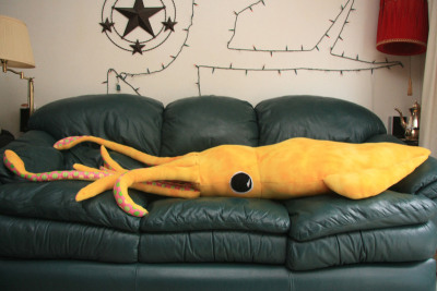 8-foot giant squid pillow.
You’ll need:
2 yards of felt
1 yard of patterned fabric (I suggest a polka dot-type pattern so it looks like suction cups)
1 medium piece of black felt, 1 medium piece of white felt (for the eyes)
white thread, black thread and thread of the same color as the felt you’re using
pins
about 5 lbs. of stuffing
a couple big sheets of paper to draw your pattern

You can find many of these things down at the many places on Fabric Row, on 4th Street between Bainbridge and Catherine. Pearl, at 417 South Street, sometimes has stuffing if you can’t find any.
First, you need to draw out your patterns. Here’s a basic template to get you started, although most of the measurements are reasonably fudgeable. If in the likely event you don’t have any four-foot-long pieces of paper lying around, just tape a few pieces together.

Once you’ve drawn out your eight patterns, it’s time to cut the fabric. Pin the pattern to the fabric, laid flat, and cut out the following, leaving a half an inch or so of extra fabric around the edge of the pattern:
FOR THE ARMS: 8 felt and 8 fabric cutouts of piece 1
FOR THE, UH, LONGER ARMS: 2 felt and 2 fabric cutouts of piece 2
FOR THE BODY: 2 felt cutouts of piece 3
FOR THE FIN: 4 felt cutouts of piece 4
FOR THE HEAD: 1 felt cutouts of piece 6
FOR THE EYES: 2 white felt cutouts of piece 7 and 2 black felt cutouts of piece 8
So now you’ve got all your pieces ready, it’s time to start sewing them together. I did mine by hand because my sewing machine is busted and I get a kind of Zen buzz from sewing by hand, but if you have a non-busted one I recommend that you use it as it will be MUCH EASIER. You’re going to be sewing everything with the nice side of the fabric facing in, then turning it inside out to stuff it.
THE ARMS: (To make a quilted pattern that looks like suckers, see this other post). Pin together one patterned fabric piece 1 and one felt piece 1 (with the nice sides facing the inside). Sew down around the U-shape and back up, leaving the top open. Then turn the arm inside out, stuff it (it’s easiest to do both of these things if you sort of scrunch it up like you’re trying to put on a pair of tights, excuse the non-dude-friendly reference) and sew the top closed. Do the same for the other seven arms and rejoice in the fact that this is the most tedious part. Same deal with the two long arms, they’re just harder to stuff. 
THE FINS: Pin together two of your piece 4s and sew together the curvy outer edge. Turn the piece inside out, so the seam you just sewed is on the inside, and start sewing up the other side, stuffing gradually as you go along. You should end up with a triangle-ish puffy thing. Repeat for the other two piece 4s.

THE BODY: Put down one piece 3, then place the two fins you have down with the point up and the curvy side pointing in, then make a sandwich by putting the other piece 3 down on top. Pin it all together and sew around the edges with the two fins still inside, as shown. Turn it inside out and move on to…

THE HEAD: So take piece 6 and the ten arms you’ve already done. Lay the arms, fabric side facing you, out with the arms’ top seams in a line half an inch from the top of piece 6. The order should be arm arm arm arm BIG ARM arm arm arm arm BIG ARM. The legs should be almost entirely covering piece 6. Pin them in place and sew a straight line through the individual legs seams to attach the legs to piece 6.
When you pick up the other side of piece 6, you now have something resembling a really weird untied hula skirt. Sew together the two 9-inch ends of piece 6 with the fabric side of the arms on the outside, and keep it inside out for the moment.
PUTTING IT ALL TOGETHER: Fit the open end of the body through the arms (still fabric side facing out) and pull the edge all the way through the felt cylinder so it’s even with the edge that DOESN’T have arms attached to it. Sew around the diameters of the head cylinder and the body cylinder to attach them, then pull the legs down over the head and you’re almost done!
Stuff the body, then seal it off by sewing piece 5 over the open end (even if you do have a functional sewing machine, you’ll probably have to do this part by hand).
THE EYES: Sew the black circles on the white circles and whipstitch the eyes onto the head. You do this last because you can’t tell where they’re going to end up on the end product if you put them on before stuffing the body.
