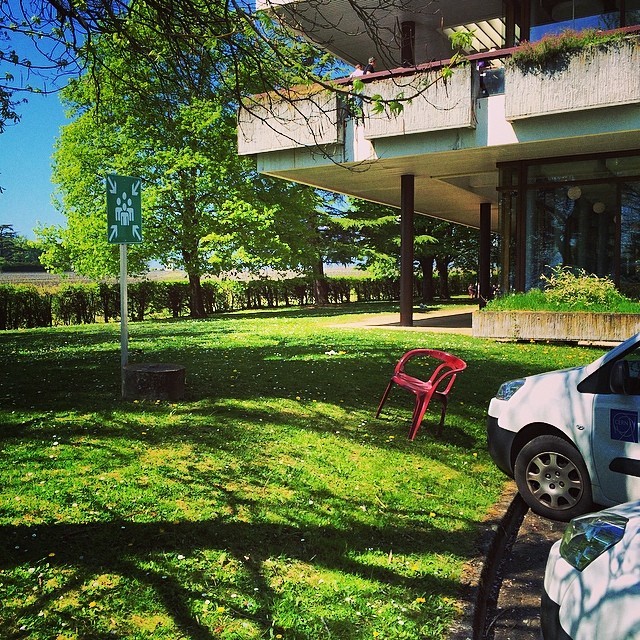 #lonelychairsatcern tilted chair in the grass of the #R2 parking #CERN