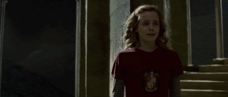 a gif of Hermione standing alone on a stairwell in the dark. She is crying.
