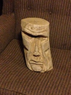 shacklefunk:  the dogs wouldn’t stop getting in my dads gross chair so he carved this weird sculpture of his own frowning face with a chainsaw and puts it on the chair when he’s not sitting in it. the dogs are scared of it 