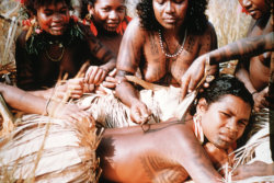 yearningforunity:    1958 image of a Motuan female tattooing the back of a young woman in Manu Manu, Papua New Guinea. Photo by Percy Cochrane  