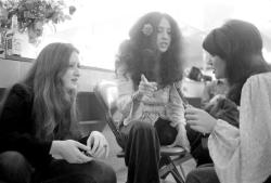 soundsof71:  Linda Ronstadt teaching harmony parts to Bonnie Raitt and Maria Muldaur backstage, keeping time with her hairbrush, 1974, by Henry Diltz