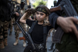 reincarnatedangel:   A Palestinian girl with a Kalashnikov rifle, amid Islamic Jihad militants in Gaza City. 