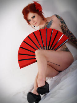 Sexy redhead with tattoos and a fan, her great legs in heels.