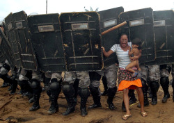 sinidentidades:  An indigenous woman with her child trying to resist the advance of Brazilian state policemen who were expelling her and some 200 other indigenous people from a privately-owned tract of land on the outskirts of Manaus, in the heart of