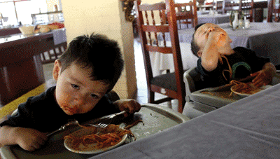 two kids falling asleep whilst eating