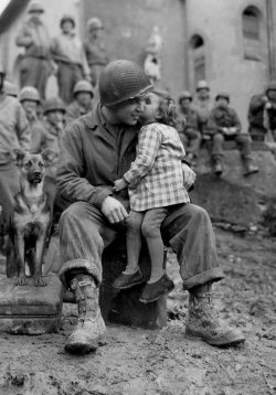bag-of-dirt:  U.S. Army technician Alvin Harley of the 9th Armored Division receives a kiss from a liberated little French girl on Saint Valentine’s Day. Abancourt, Oise, Picardy, France. 14 February 1945. 