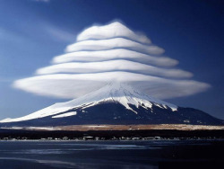  Lenticular clouds over Mount Fuji, Japan. These are stationary lens-shaped clouds that form at high altitudes, usually perpendicular to the direction of the wind. 