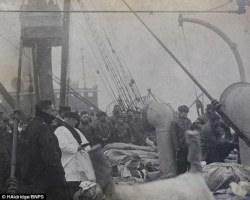    A priest praying over the victims of the Titanic (1912).  