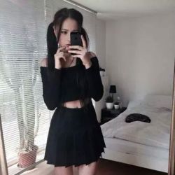 pleatedminiskirts:  She is great! Ever so slightly gothic? The skirt is great (American Apparel Tennis Skirt? ) and her “off the shoulder top” leaving some midriff to show is so lovely.