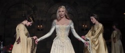 costumefilms:  Snow White and the Huntsman (2012) - Charlize Theron as Queen Ravenna wearing a white wedding dress with brocade corseted bodice and pleated skirt. The skin-tight sleeves are embellished by gold lace-up details, which can be found on the