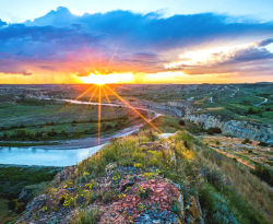 americasgreatoutdoors:The Wind Canyon Trail is one of the best places to enjoy the sunset at Theodore Roosevelt National Park in North Dakota. The last light shines on the badlands and sparkles in the water. The ever-changing Little Missouri River varies