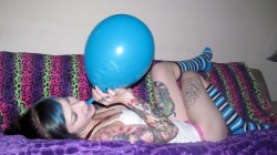 CatCandescent blows balloons in her living room