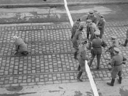 greasegunburgers:  West Berlin policemen and East German Volkspolizei face each other across the border after a young girl managed to cross the border into West Berlin. 