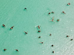 laymouni:  292102909029-deactivated2014082:Dead Sea, Israel Occupied PalestineSwimmers who are probably settlers float effortlessly in the salt-laden waters of the Dead Sea in near Ein Bokek, Israel Palestine. Ten times saltier than seawater (nearly as