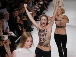 Activists of the feminist movement FEMEN protest on the catwalk as models present creations for Nina Ricci during the 2014 Spring/Summer ready-to-wear collection fashion show
