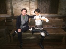 Isayama Hajime’s editor, Kawakubo Shintaro, takes a photo with the new tea-drinking Levi clonoid at Universal Studio Japan’s SNK THE REAL exhibition! Also featured in this year’s exhibition is a transforming Eren clonoid with Titan feet!Images
