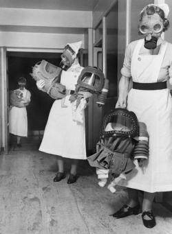 indypendent-thinking:  Three nurses carry babies cocooned in baby gas respirators down the corridor of a London hospital during a gas drill during WWII 