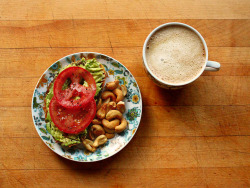 garden-of-vegan:  Roasted garlic toast topped with mashed avocado, sliced tomato, salt, pepper, and lime. Roasted cashews and coffee with vanilla soy milk.  Yommmm