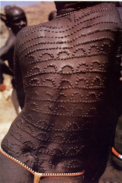 Africa | Scarification on a Nuba woman marking the weaning of her first child. The scarification is achieved by hooking the skin with a thorn and then cutting it with a small knife.