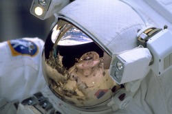 humanoidhistory:SPACEMAN 1999 — The Earth and cargo bay of the Space Shuttle Discovery are reflected in the helmet visor of an astronaut, December 1999.(NASA)