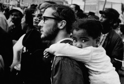  A white man carries a black girl on his shoulders during a march with Dr. Martin Luther King, Jr. Alabama, ca. 1965.   