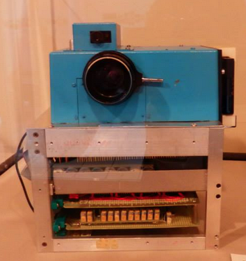 Very old digital camera with a blue camera bit and a box for the electronics