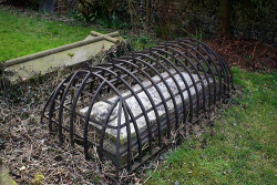 unexplained-events:  This is a grave from the Victorian age when a fear of zombies and vampires was prevalent. The cage was intended to trap the undead just in case the corpse reanimated.Also humans. Keep them out too 