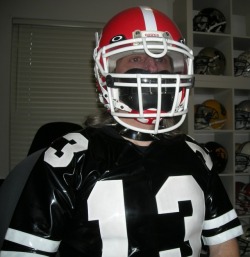 hockeydogwoof:Leather padded gag on under the football helmet along with PVC football jersey and spiked metal collar.