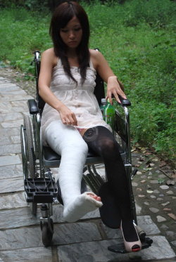 Poor girl with broken leg in wheelchair 