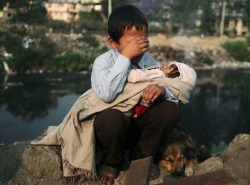 sixpenceee:A boy in Nepal being evicted from his homeA boy cries as he holds his sister in his lap after a confrontation with squatters and police personnel in Kathmandu, Nepal.