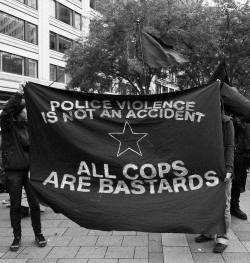 thisisableism:  [Image Description: Two people hold up a flag that reads, “Police violence is not an accident. All cops are bastards.”] 