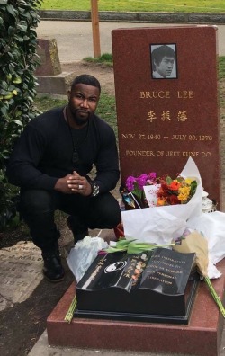 butts-and-uppercuts:  Michael Jai White at Bruce Lee’s grave.  It’s pretty crazy to see how many flowers are on Bruce’s grave…still. 