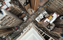 felibre:  Midtown intersection, NYC. Watching the pace and flow of New York City from above is amazing. The constant stream of yellow taxis lining the avenues, the waves of pedestrians hurriedly crossing with the change of traffic signals, little figures