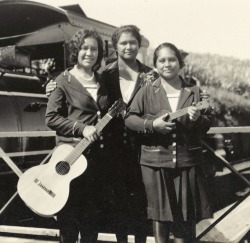 mudwerks:Three young women with a guitar and a ukelele, stand in front of a Hawaii Consolidated Railway steamtrain, Hilo Region, Hawaii, 1929 / C.M. Yonge (by National Library of Australia Commons)