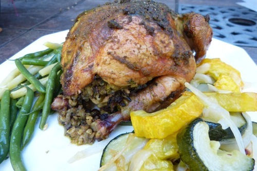 cooked chicken with stuffing and roasted vegetables on serving platter