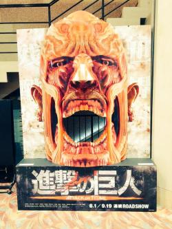 fuku-shuu:  The Colossal Titan cinema display (Announced yesterday as part of the SnK live action films’ promotion) has been captured in person!As the example shows, you can pose behind it and pretend to be eaten!ETA 2015/06/14:Clearly Japanese children