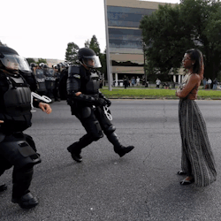 its-a-different-world:  mujeristaxicana:  arrest-my-skin:  thingstolovefor:    “A woman was standing calmly, her long dress the only thing moving in the breeze, as two police officers in full riot gear confronted her in the middle of a roadway to arrest
