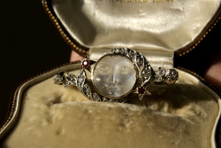 omgtsn:cemeterywind:Late Victorian brooch with a man in the moon cameo carved from transparent moonstone, set in white and rose gold with a border of diamonds and rubies.you tellin me that the moon emoji has been around for centuries