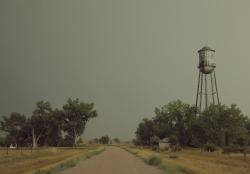 kylejthompson:  I found a ghost town while driving though the midwest. I spent the day wading through dead grass and exploring the vacant homes.  A rusty water tower lay on the outskirts of the town and the yards were littered with old cars.  New life