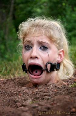 slavegirldiana:  Buried with mouth held wide open you never know what will crawl into her mouth. No wonder she looks scared. 