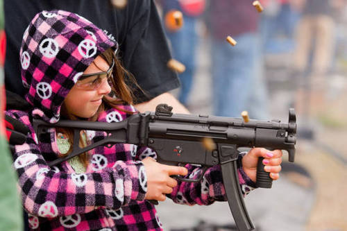 Little girl shooting machine gun