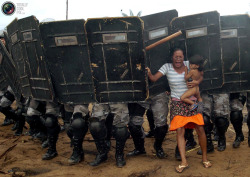 golden-zephyr:  An indigenous woman holds her child while trying to resist the advance of Amazonas state policemen who were expelling the woman and some 200 other members of the Landless Movement from a privately-owned tract of land on the outskirts of