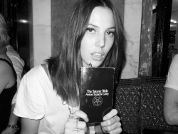 terrysdiary:  Ruby Aldridge at Cafe Flore holding her copy of The Satanic Bible. 