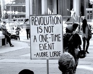 [Sign with quote by Audre Lourde: &ldquo;Revolution is not a one-time event.&rdquo;]