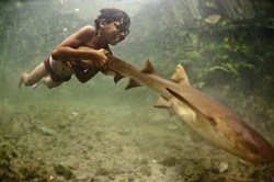 thedailywhat:  Kickass Kid of the Day: Yes, this shot is real — photographer James Morgan submitted it to this year’s National Geographic Traveler Photo Contest:  Enal, a young sea nomad, rides on the tail of a tawny nurse shark, in Sulawesi,