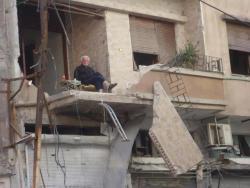  Syrian man drinking tea after his house was bombed  